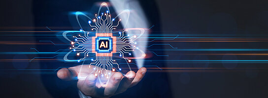 Geschäftsmann hält ein digitales Symbol für AI in der Hand.