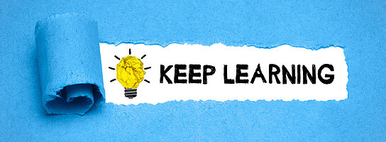 Keep Learning steht auf einem blauen Hintergrund